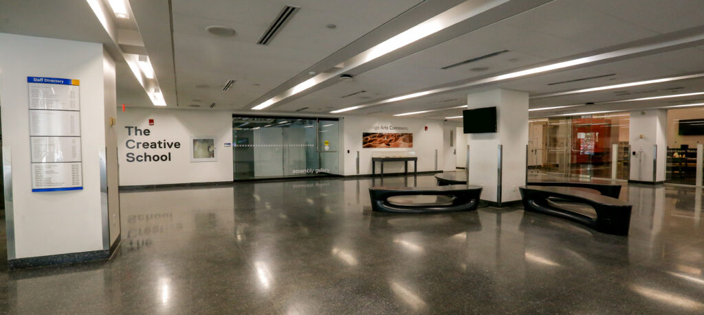The sleek, well-lit lobby of 'The Creative School' and 'Image Arts Commons,' featuring a staff directory, glass gallery doors, and modern dark benches on a highly reflective floor.